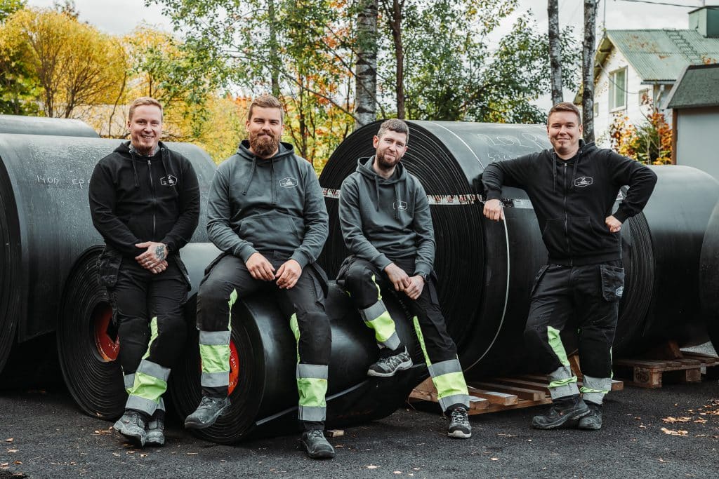 Suomen Kuljetinhuolto Oy:n asentajat nojaamassa kumimattorulliin.